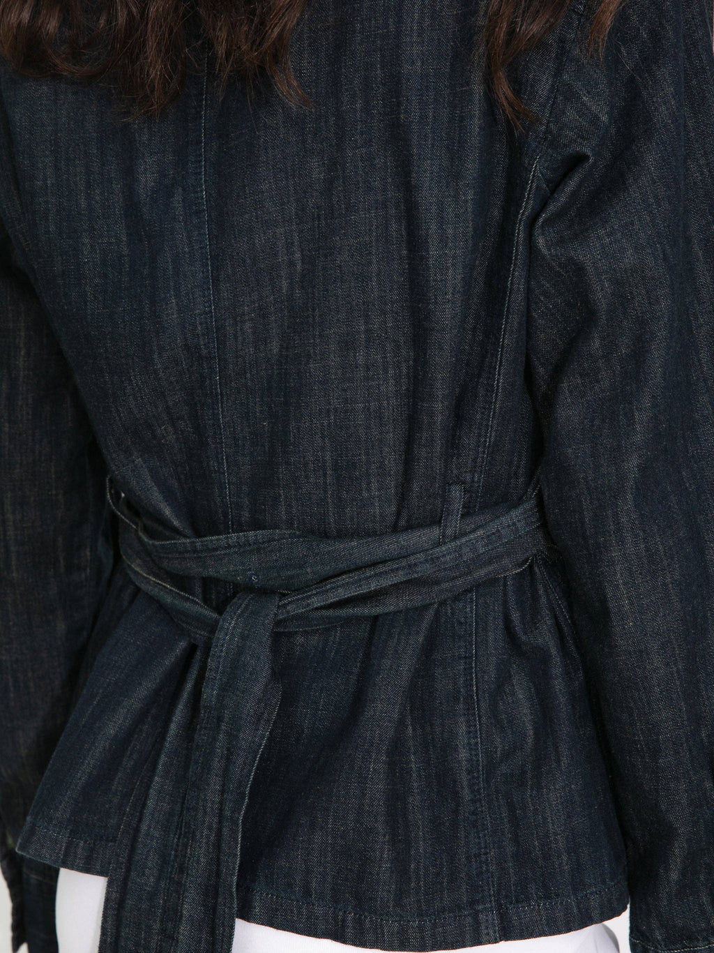 Dark denim jacket with a belt worn by a person