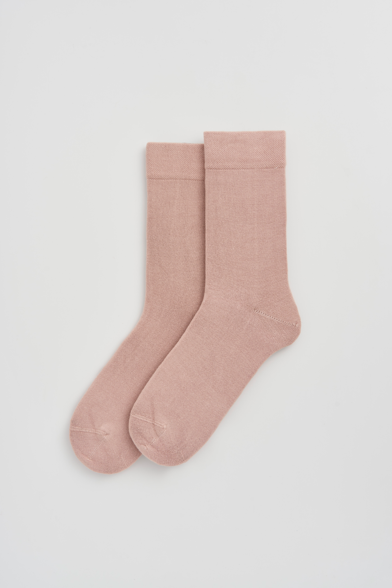 Pair of pink socks on a light gray background