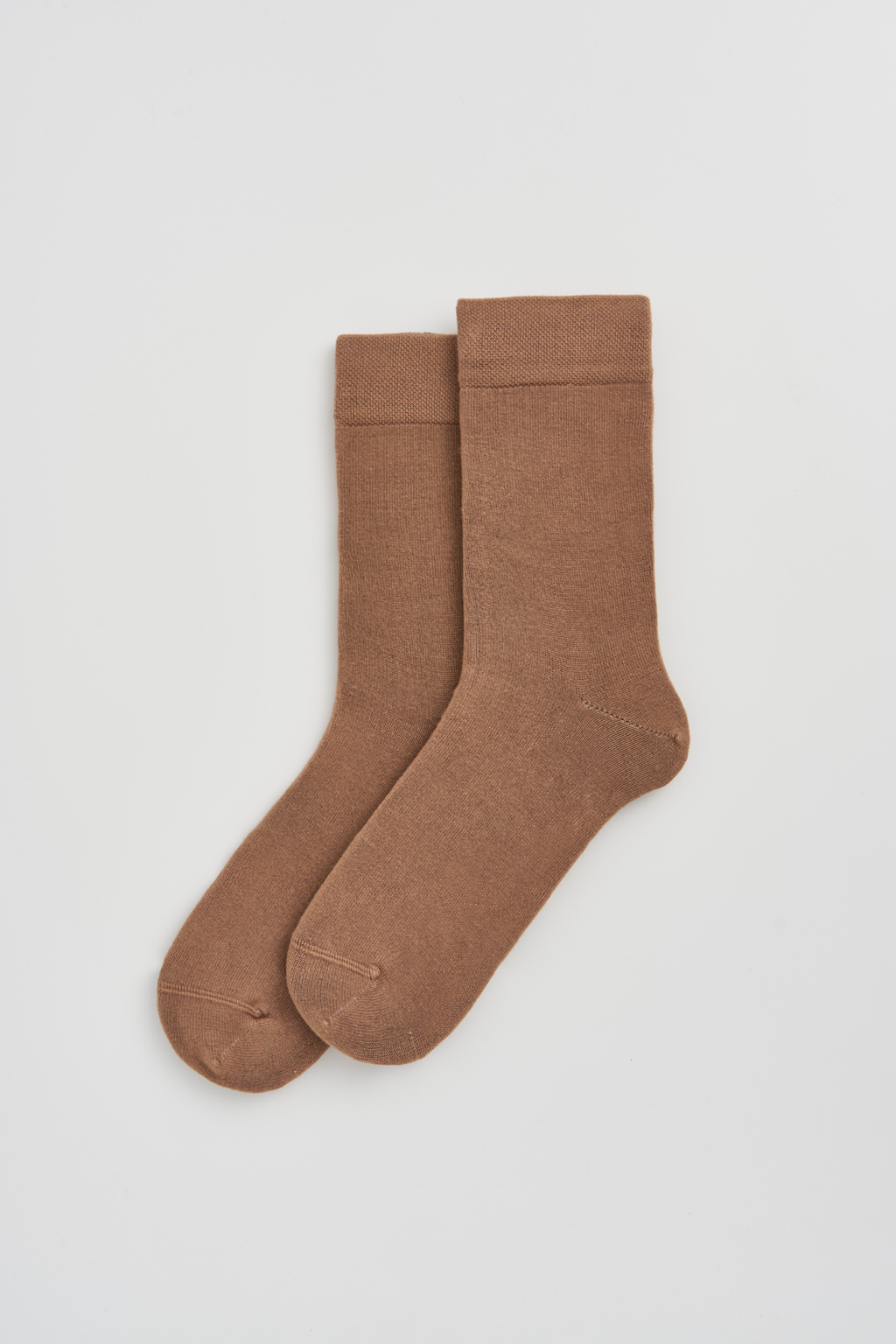 Pair of brown socks on a light gray background