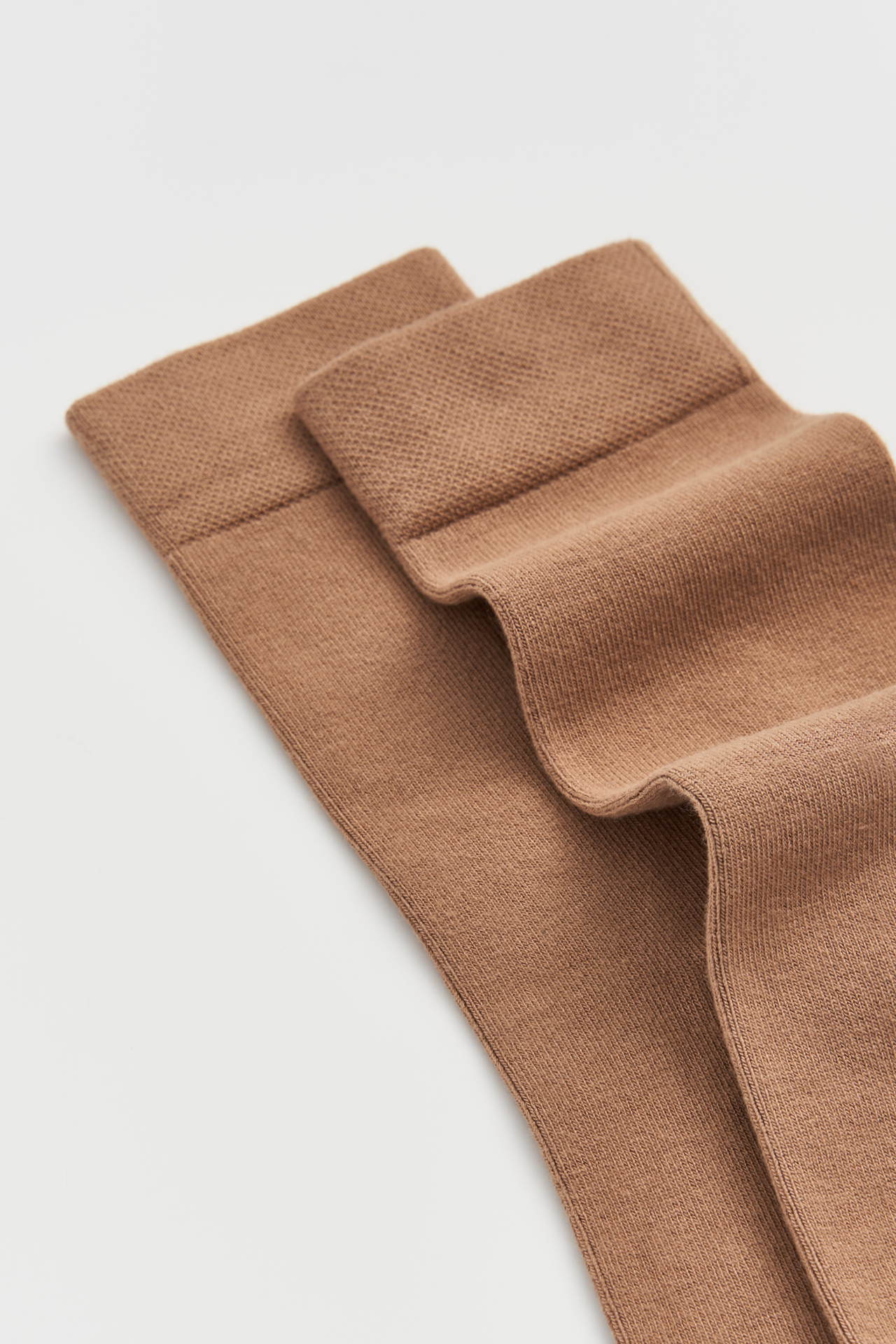 Brown fabric with ruffled edge on a light gray background