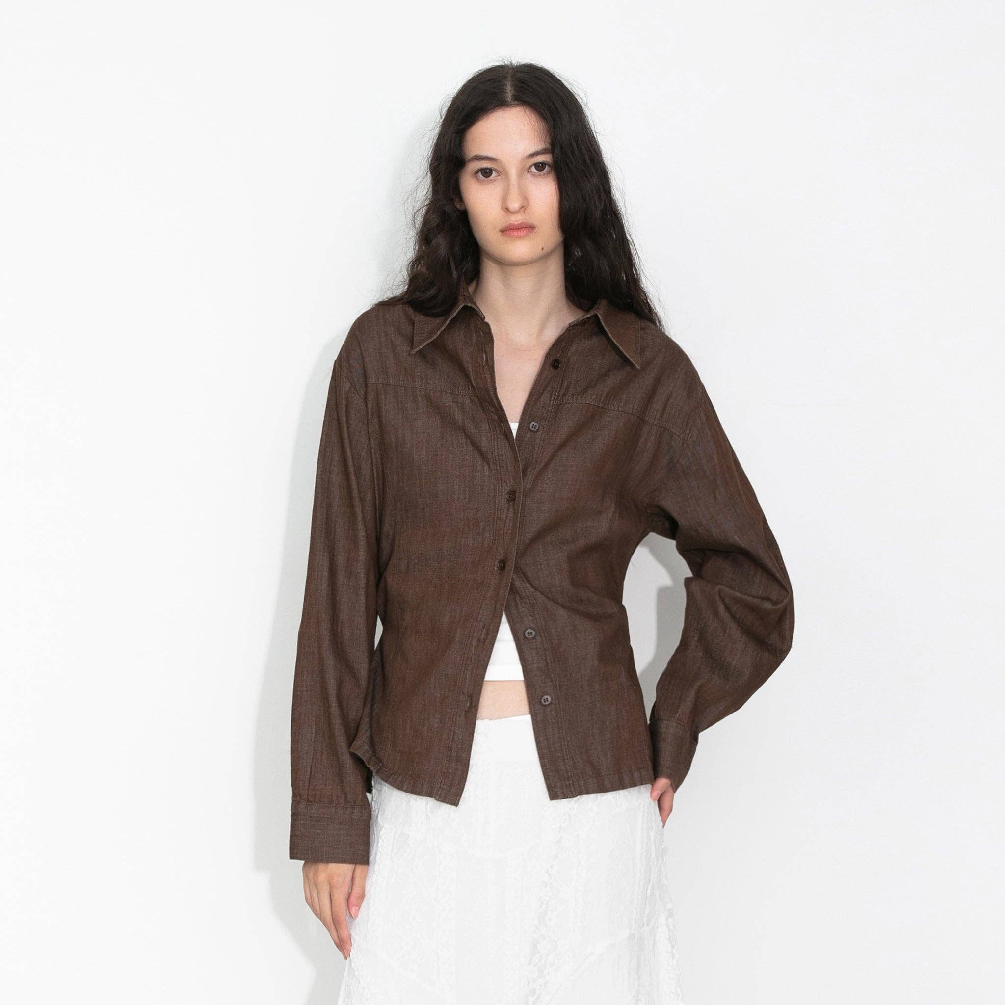 Woman wearing a brown shirt and white pants on a white background