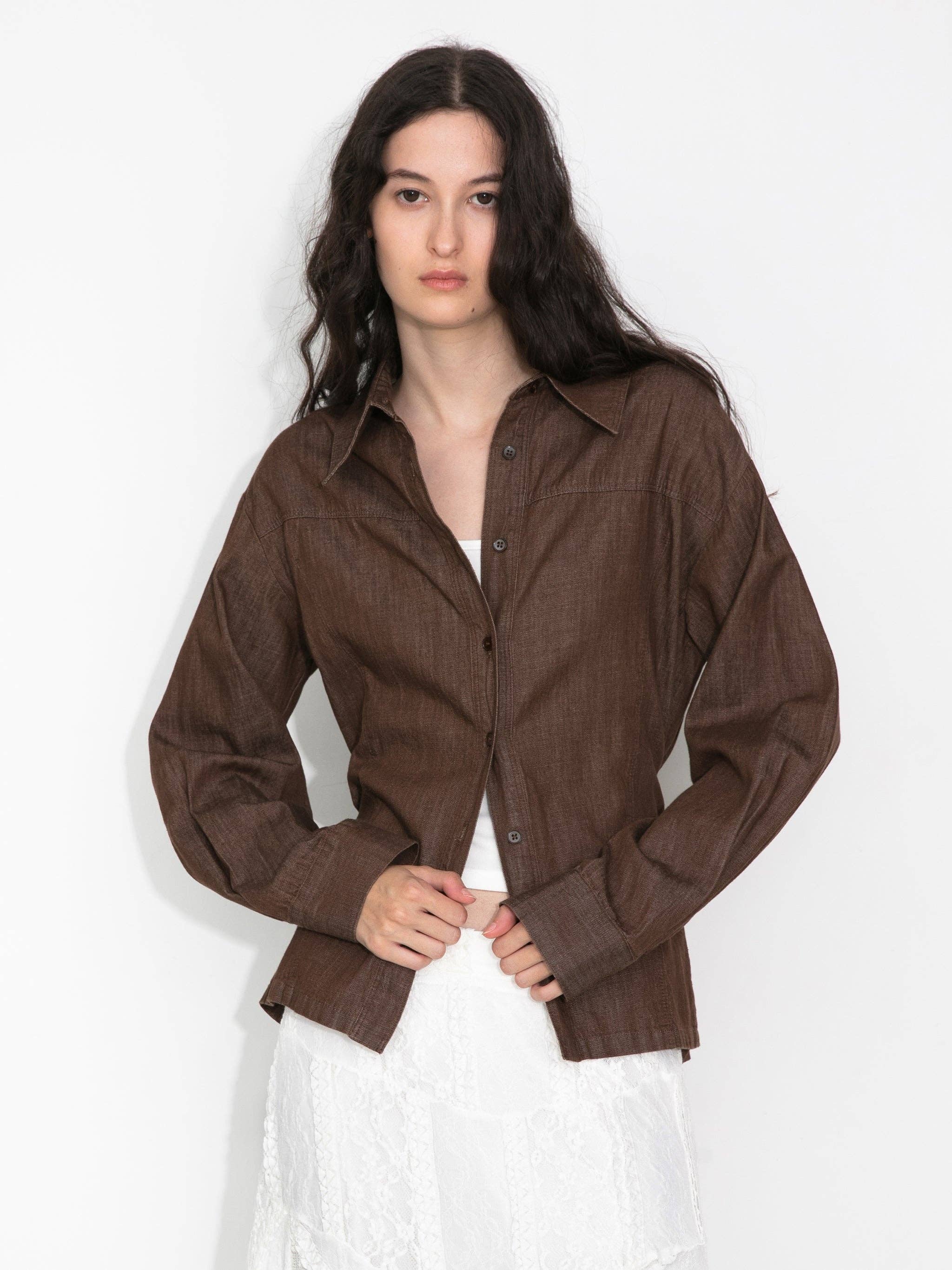 Woman wearing a brown button-up shirt on a white background