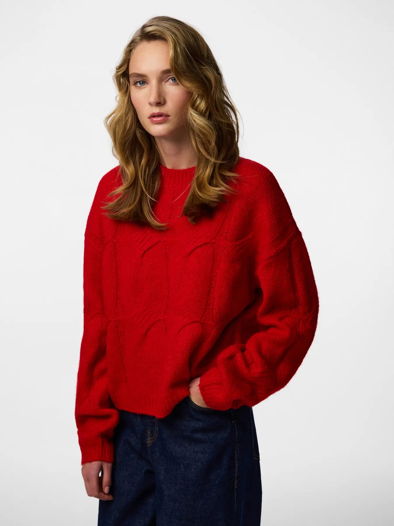 Woman wearing a red sweater against a white background