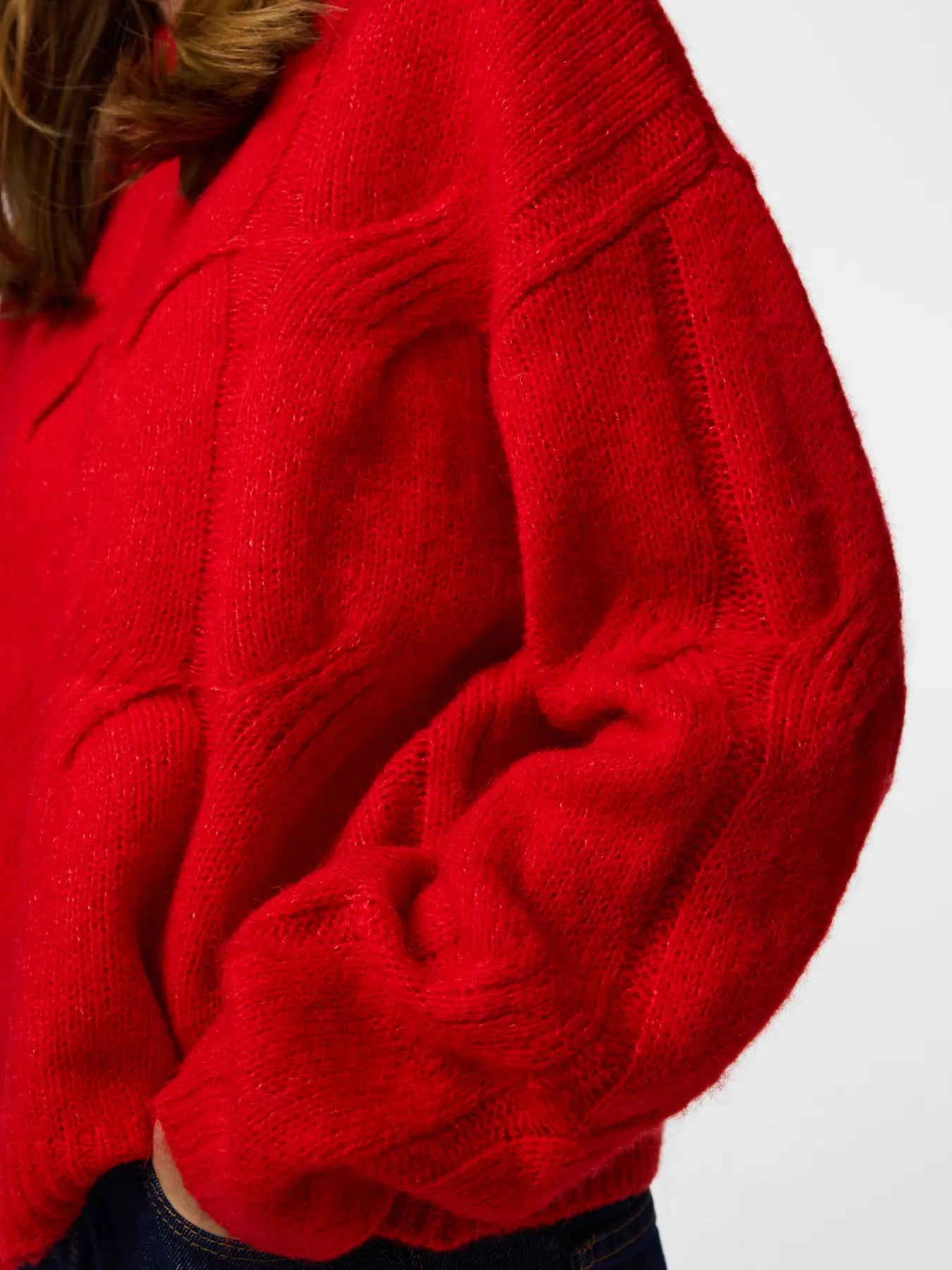 Close-up of a red sweater with a white background