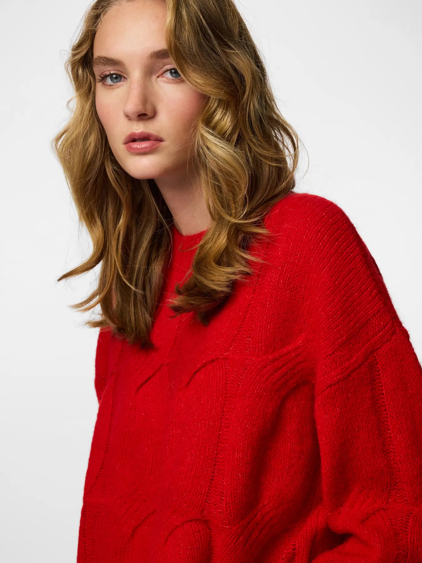 Woman wearing a red sweater against a white background