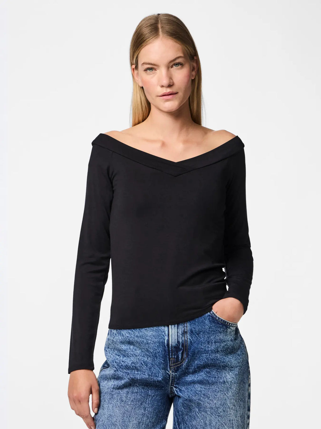 Woman wearing a black off-shoulder top and blue jeans on a white background