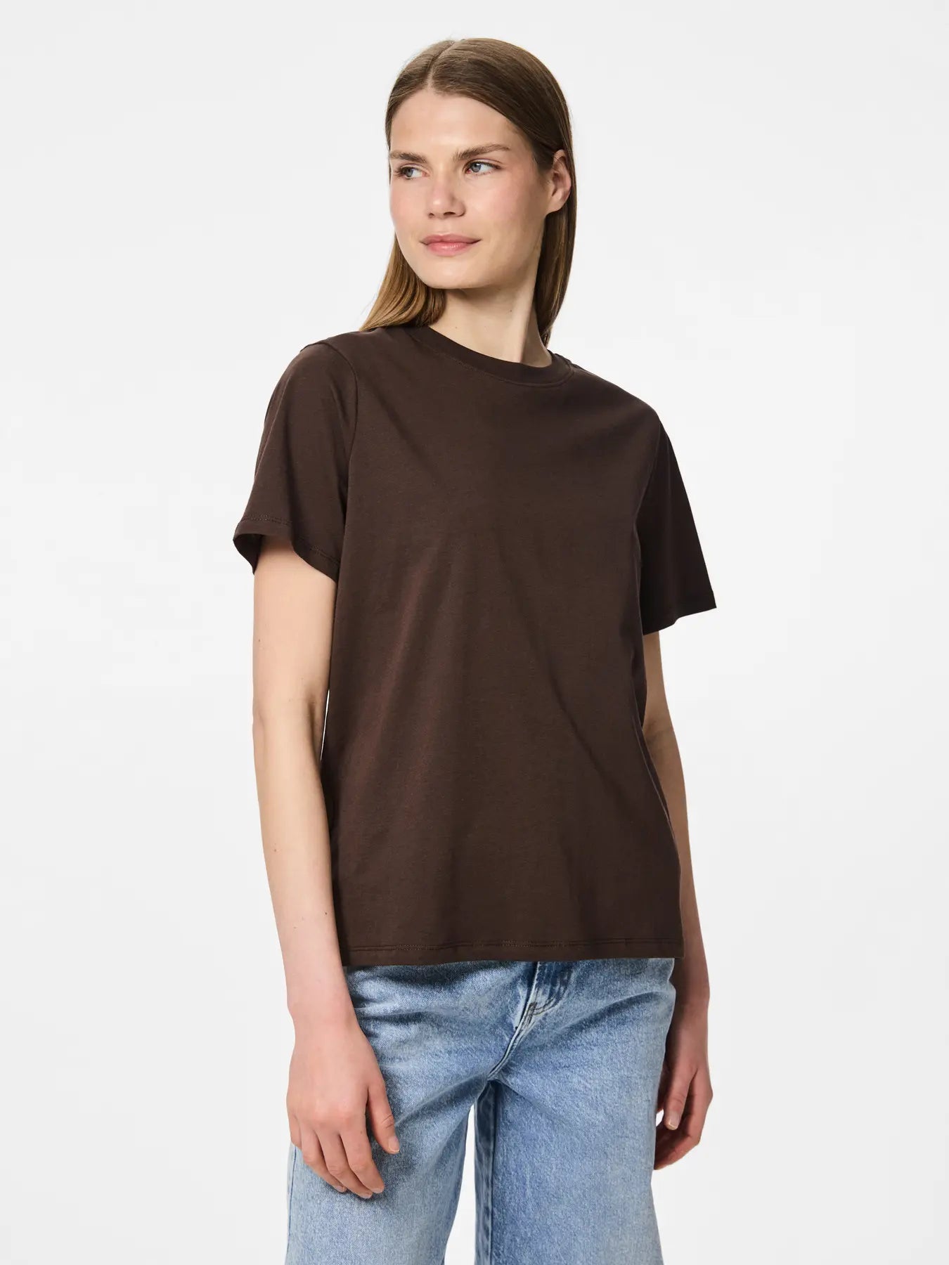 Woman wearing a brown t-shirt and blue jeans on a white background