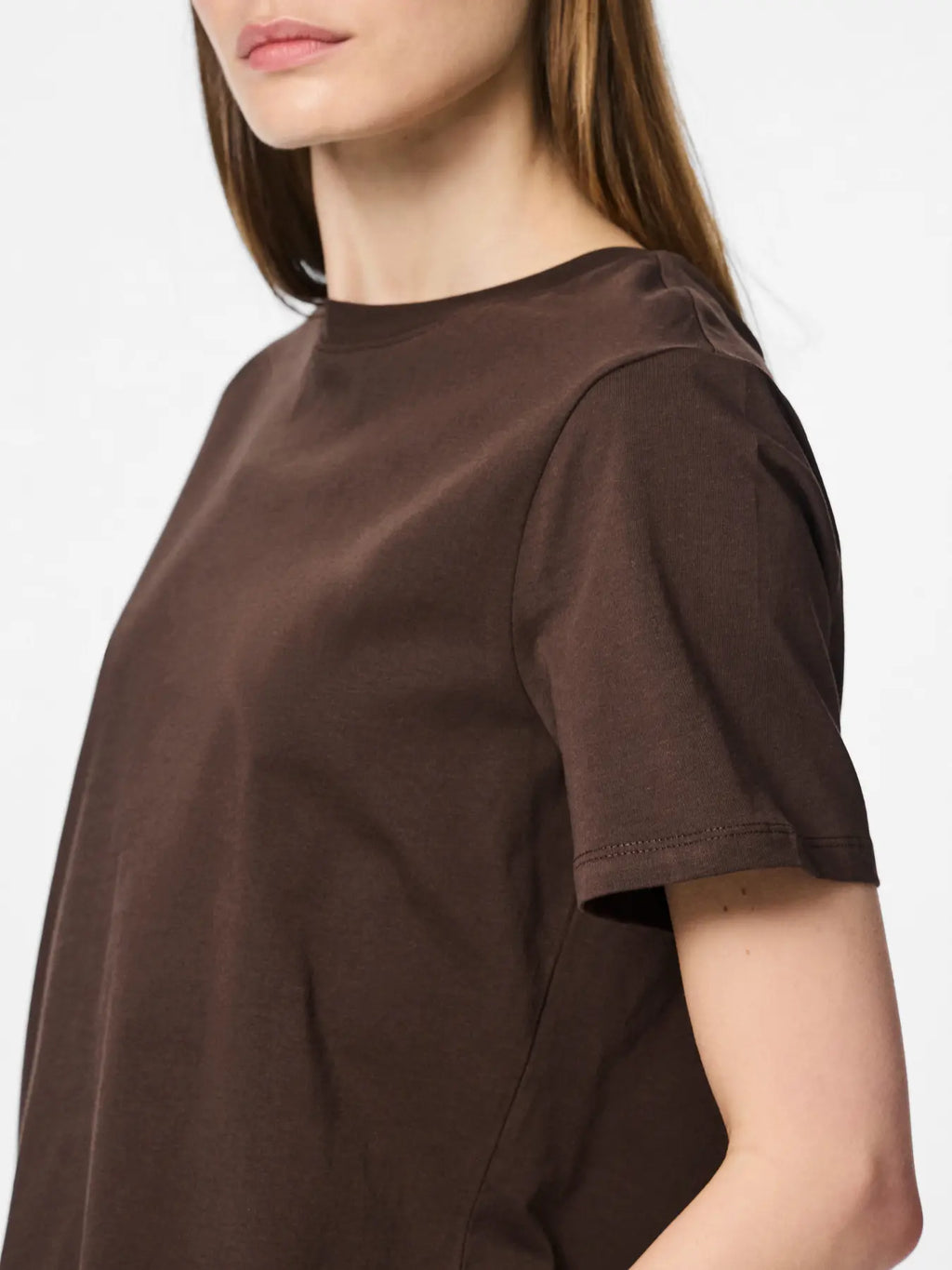 Brown t-shirt worn by a person on a white background