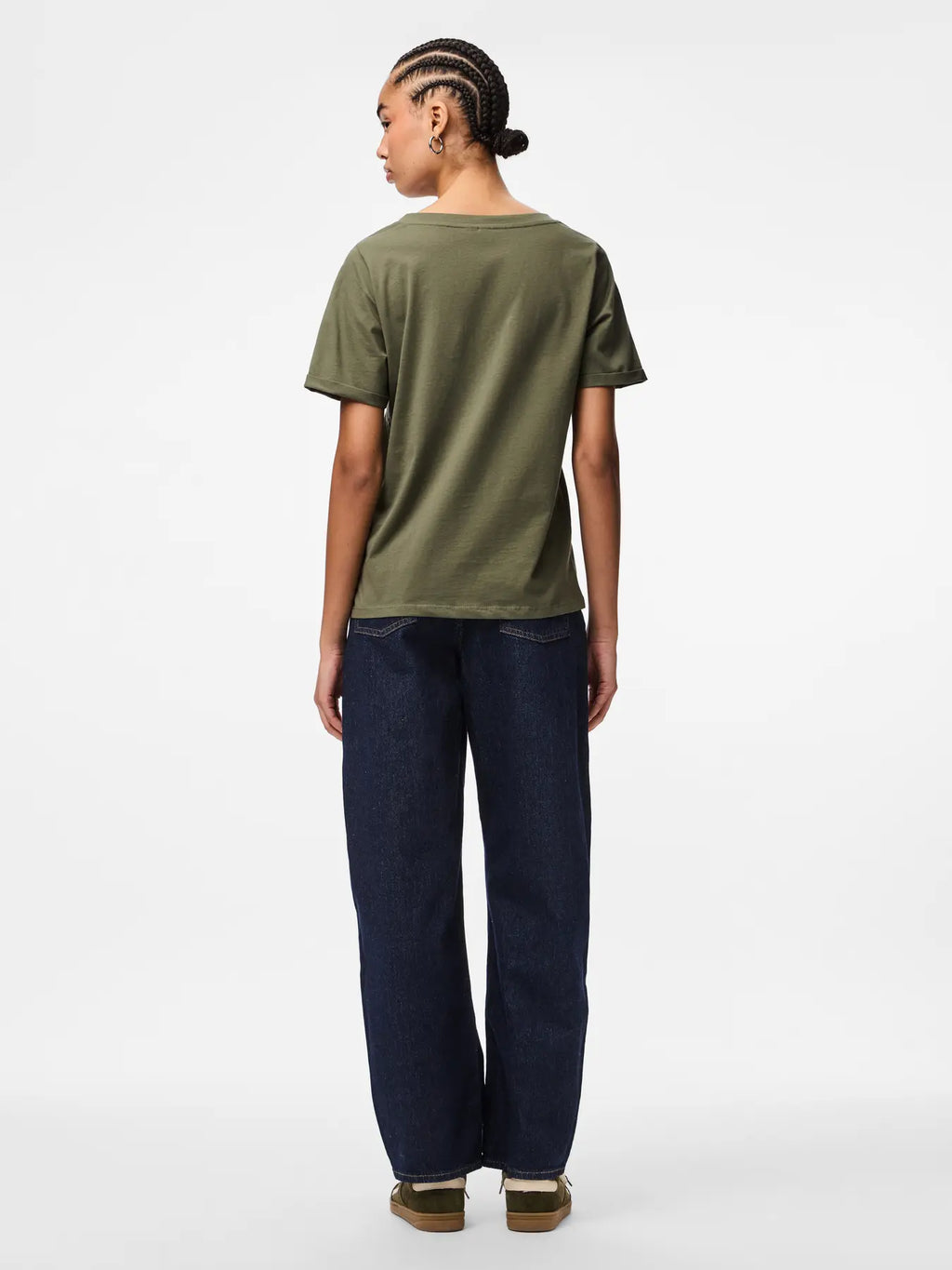 Person wearing an olive green t-shirt and dark blue jeans on a white background