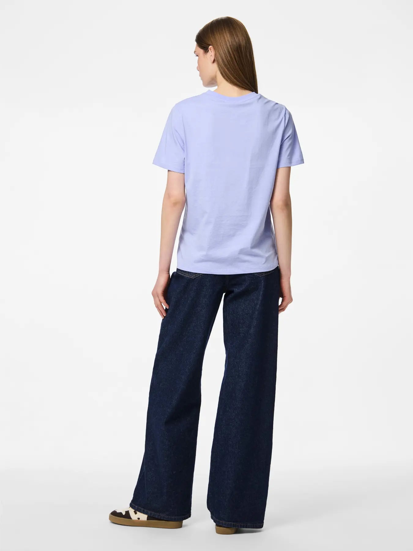 Person wearing a light blue t-shirt and dark blue pants on a white background