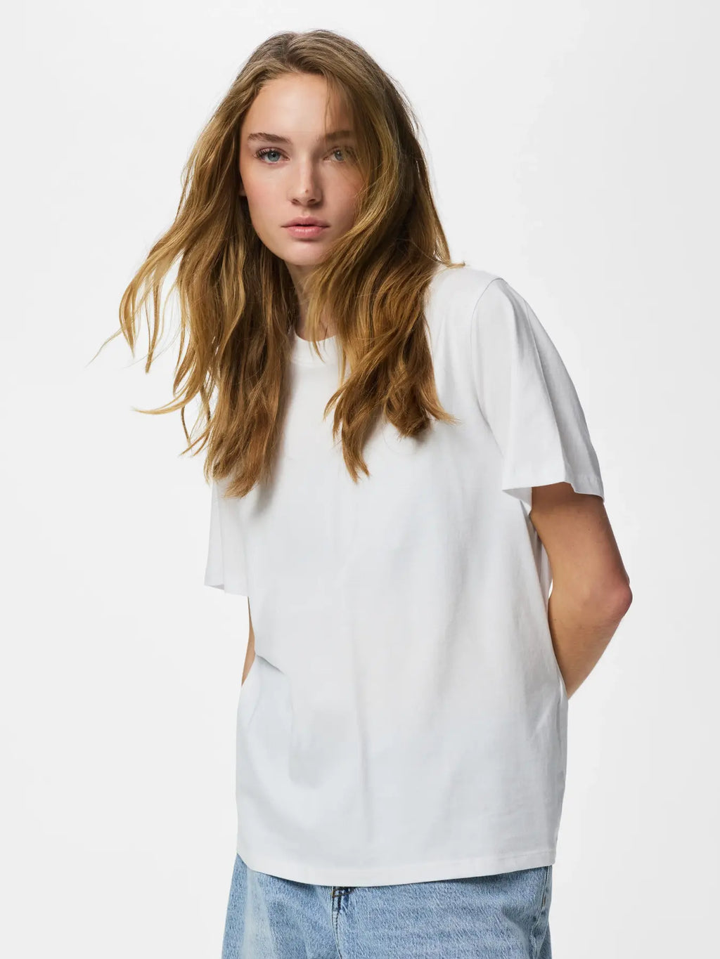 Person wearing a plain white t-shirt against a light background