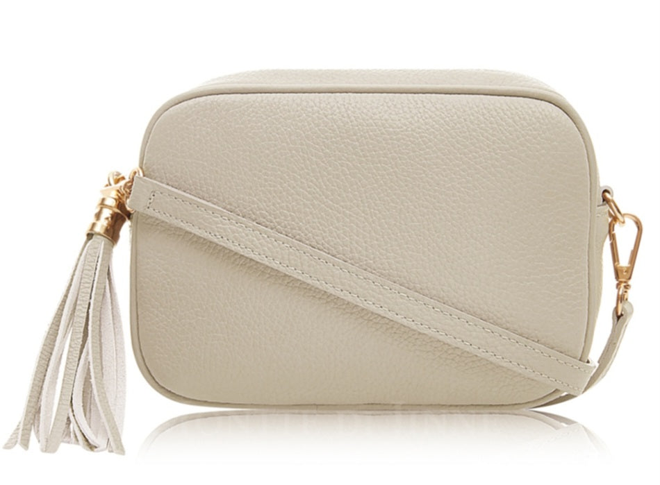 Beige crossbody bag with a tassel on a white background