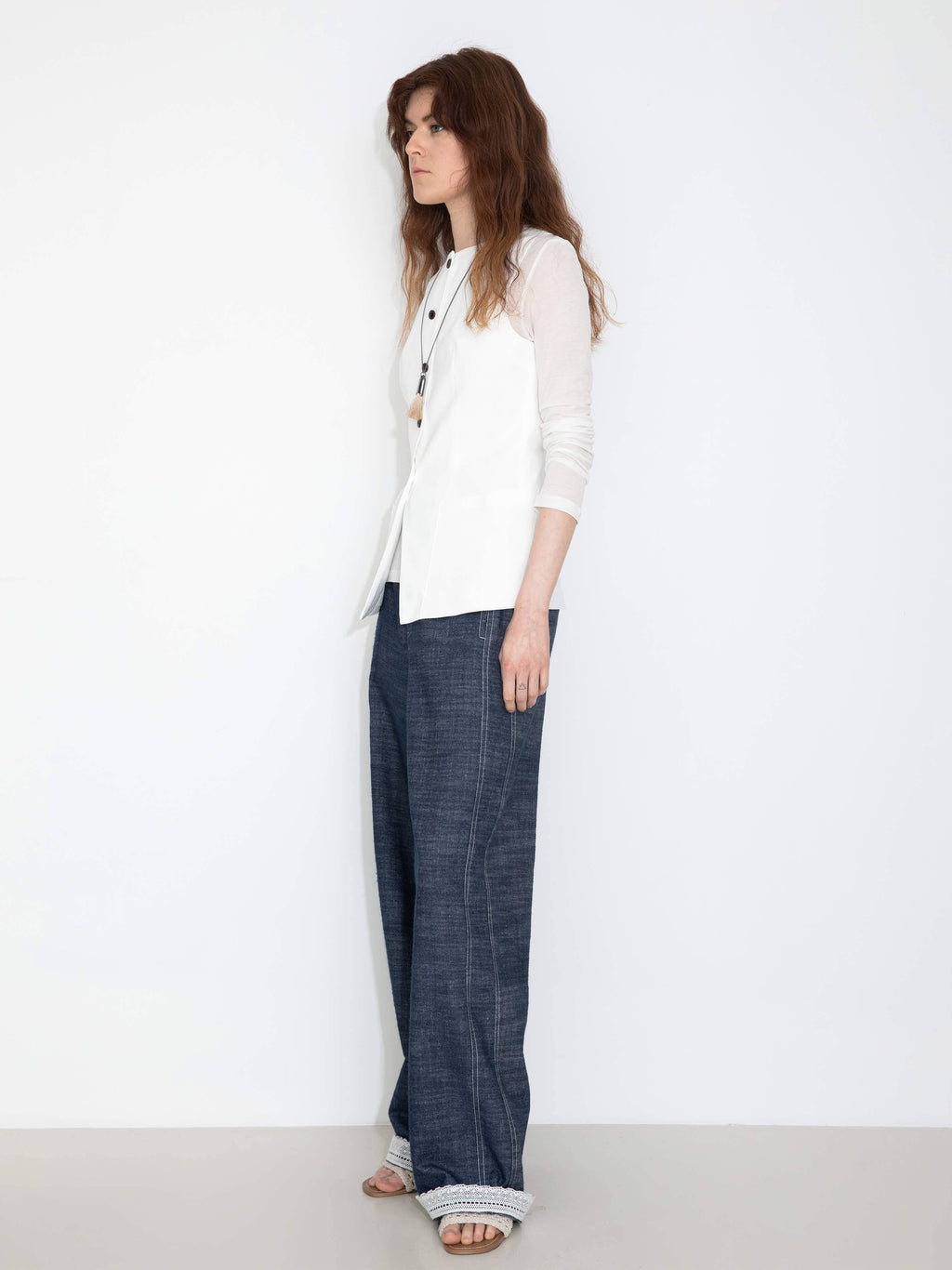 Woman wearing a white blouse and blue pants on a white background