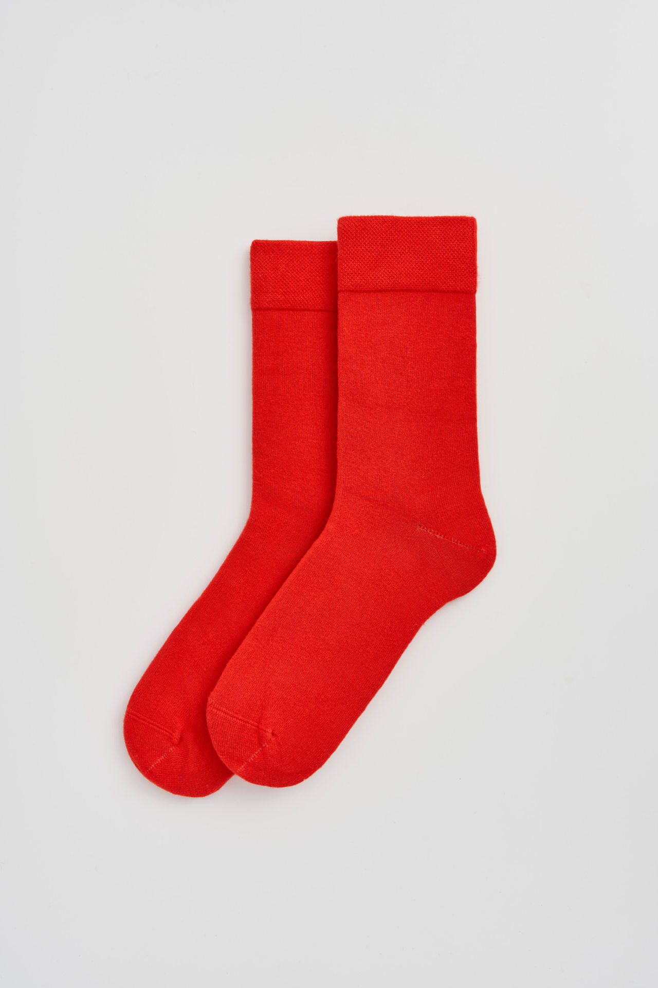 Pair of red socks on a light gray background