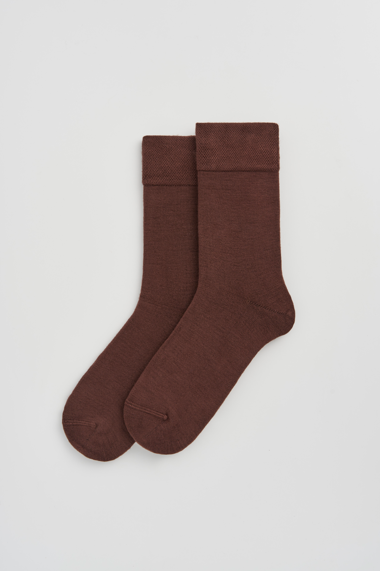 Pair of brown socks on a light gray background