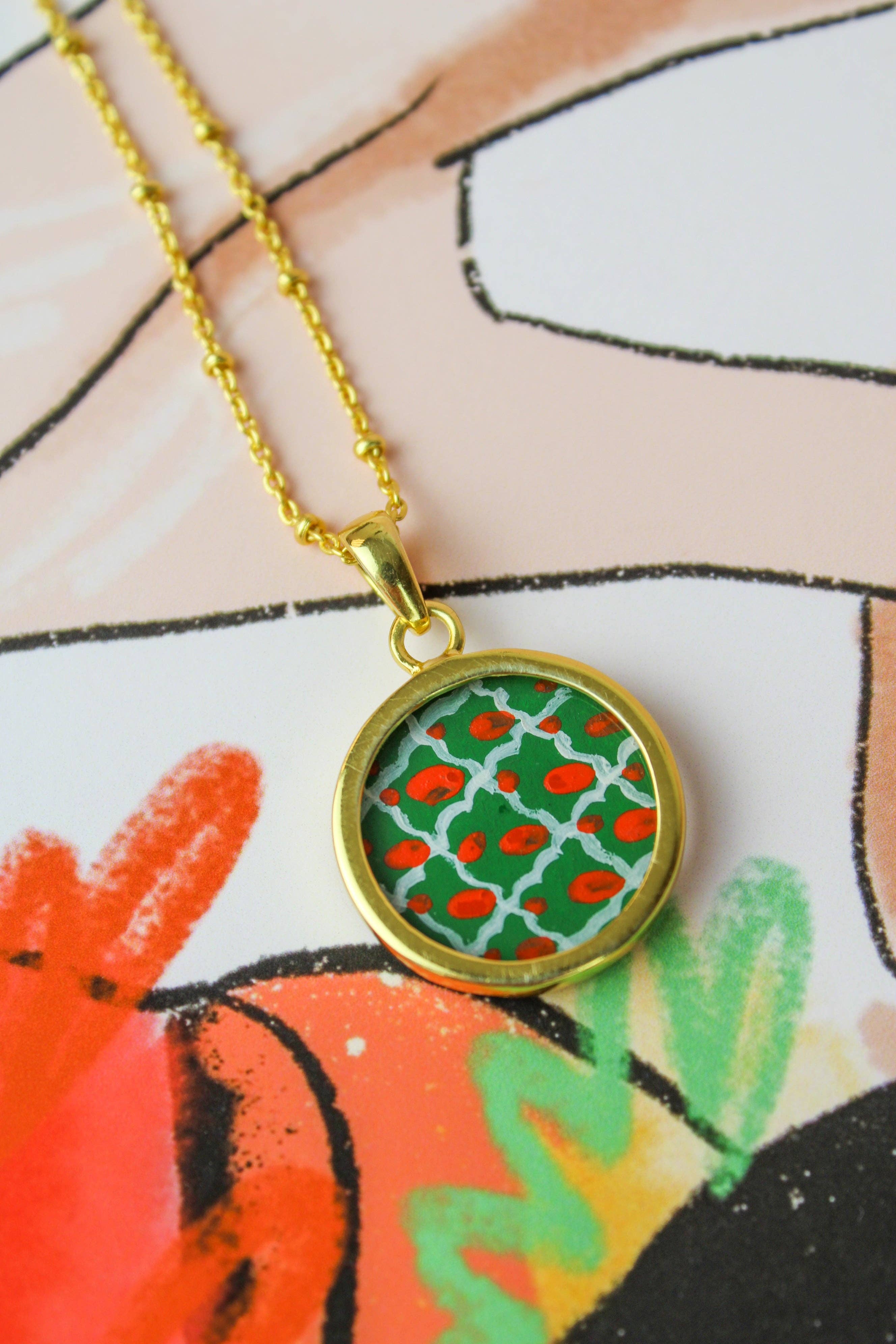 Necklace with a green and red patterned pendant on a colorful background