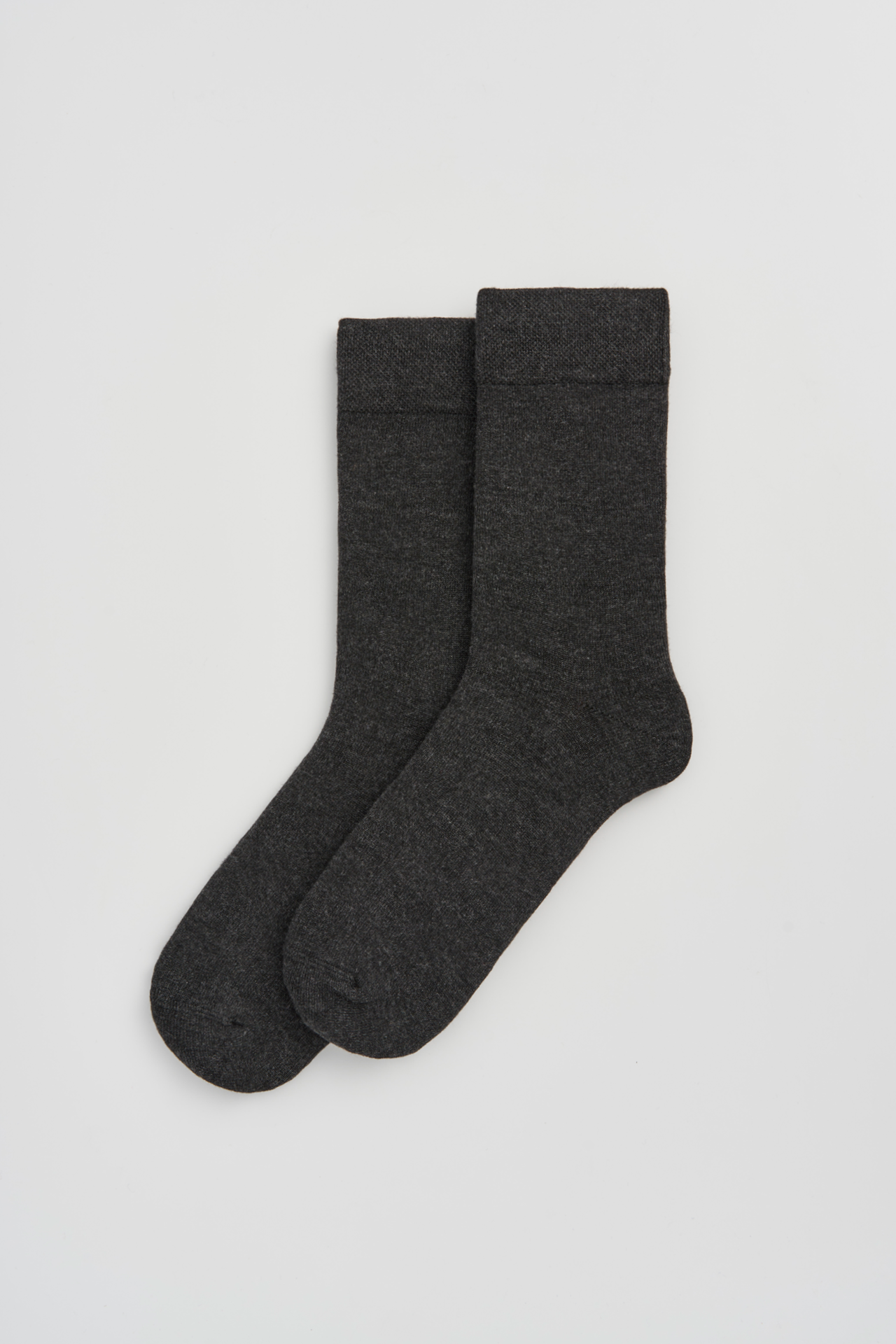 Pair of dark gray socks on a light gray background