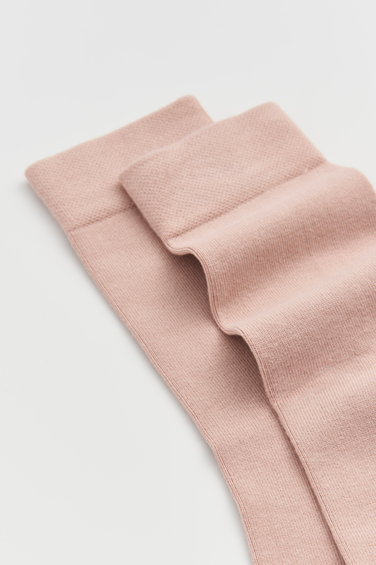 Pink fabric with a textured pattern on a light gray background
